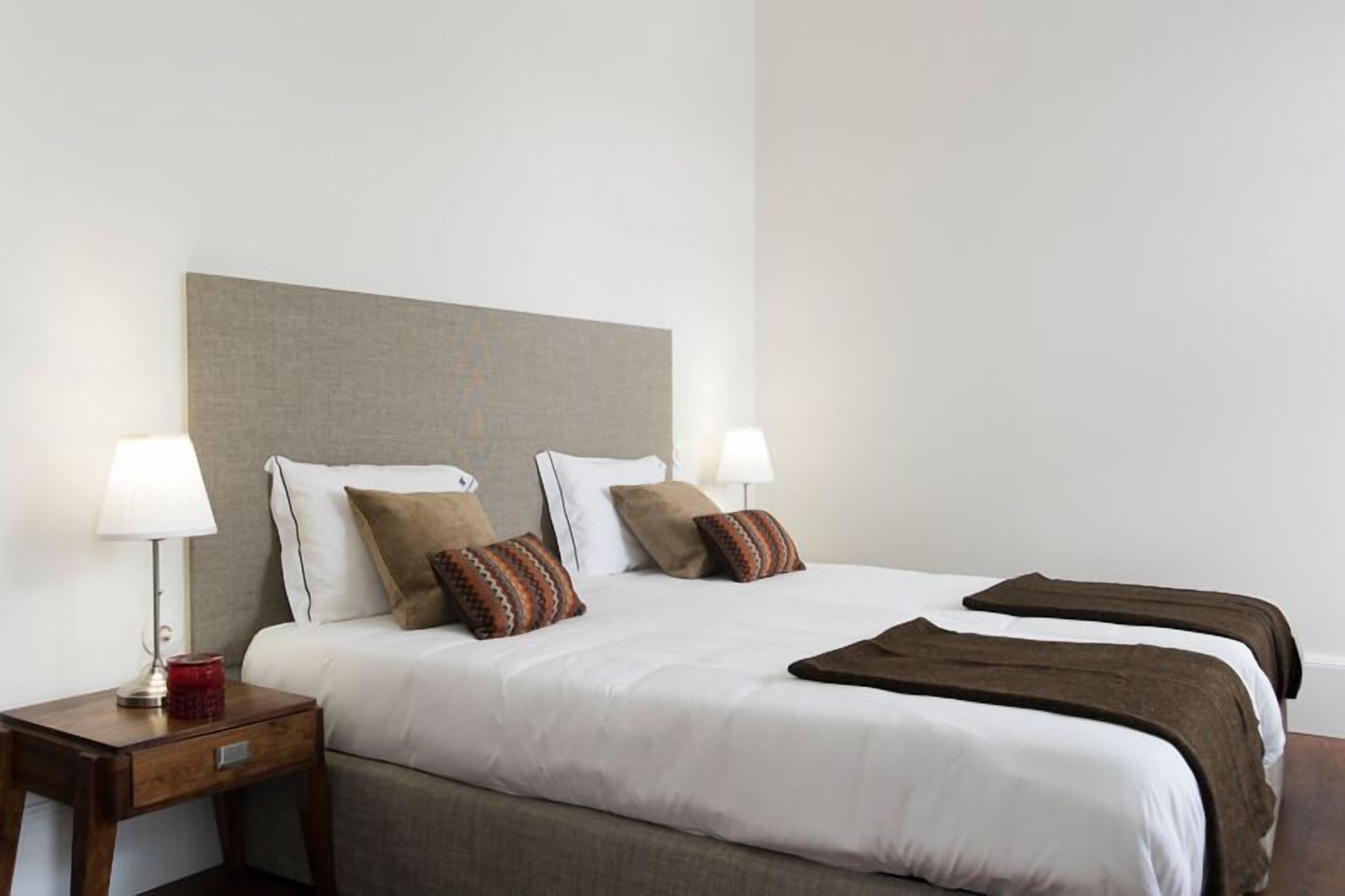 Ein Hotelzimmer mit einem großen Bett, zwei Nachttischen und einer Kopfteil.