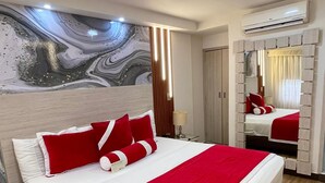 A hotel room with a large bed, a marble wall, and a modern design.
