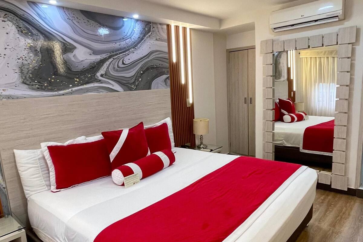 A hotel room with a large bed, a marble wall, and a modern design.