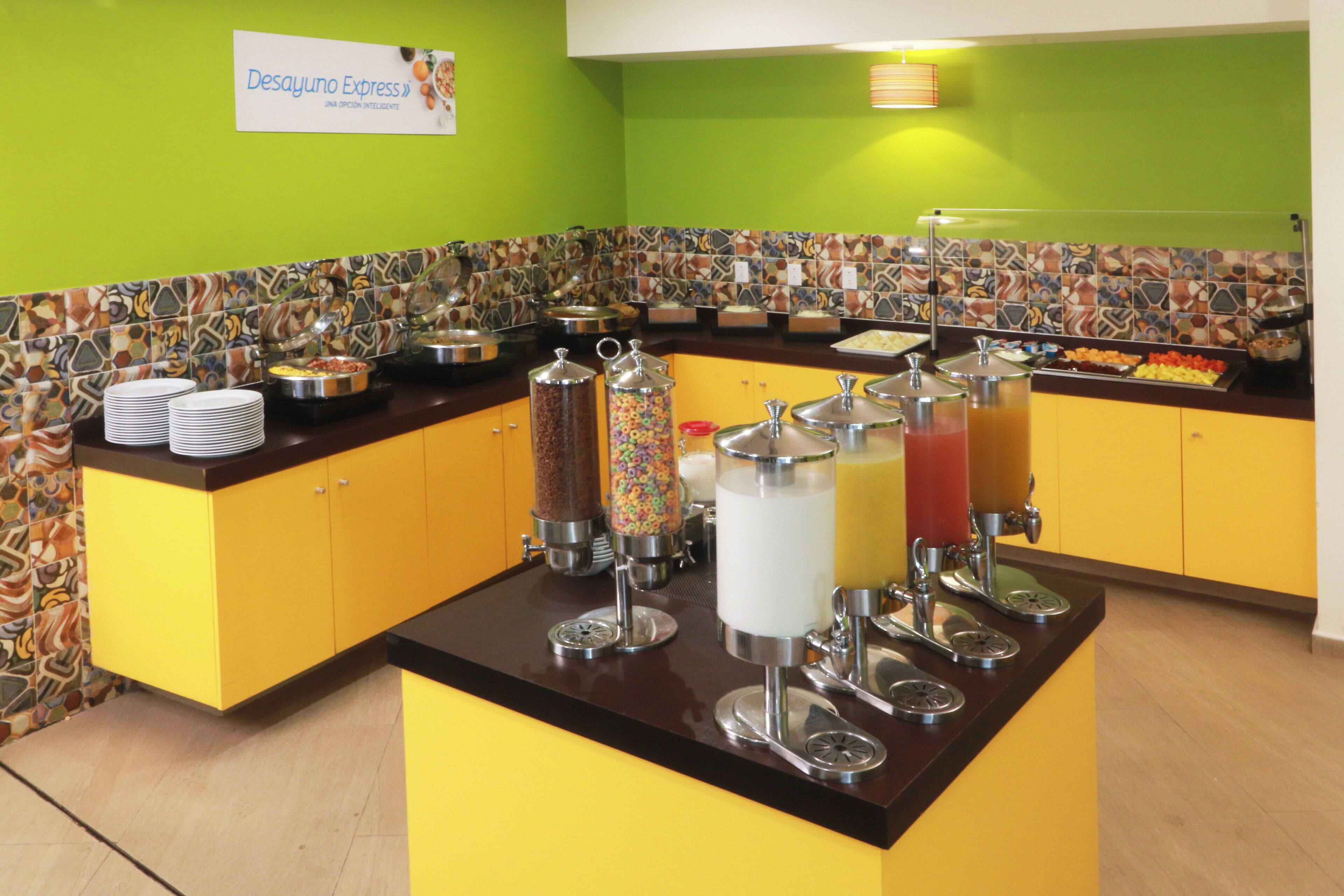 Un espace buffet avec différents récipients contenant de la nourriture et un panneau indiquant « Desayuno Express ».