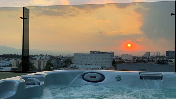 Un jacuzzi con vista a la ciudad al atardecer.