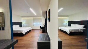 Habitación de hotel con dos camas, un escritorio y una silla.