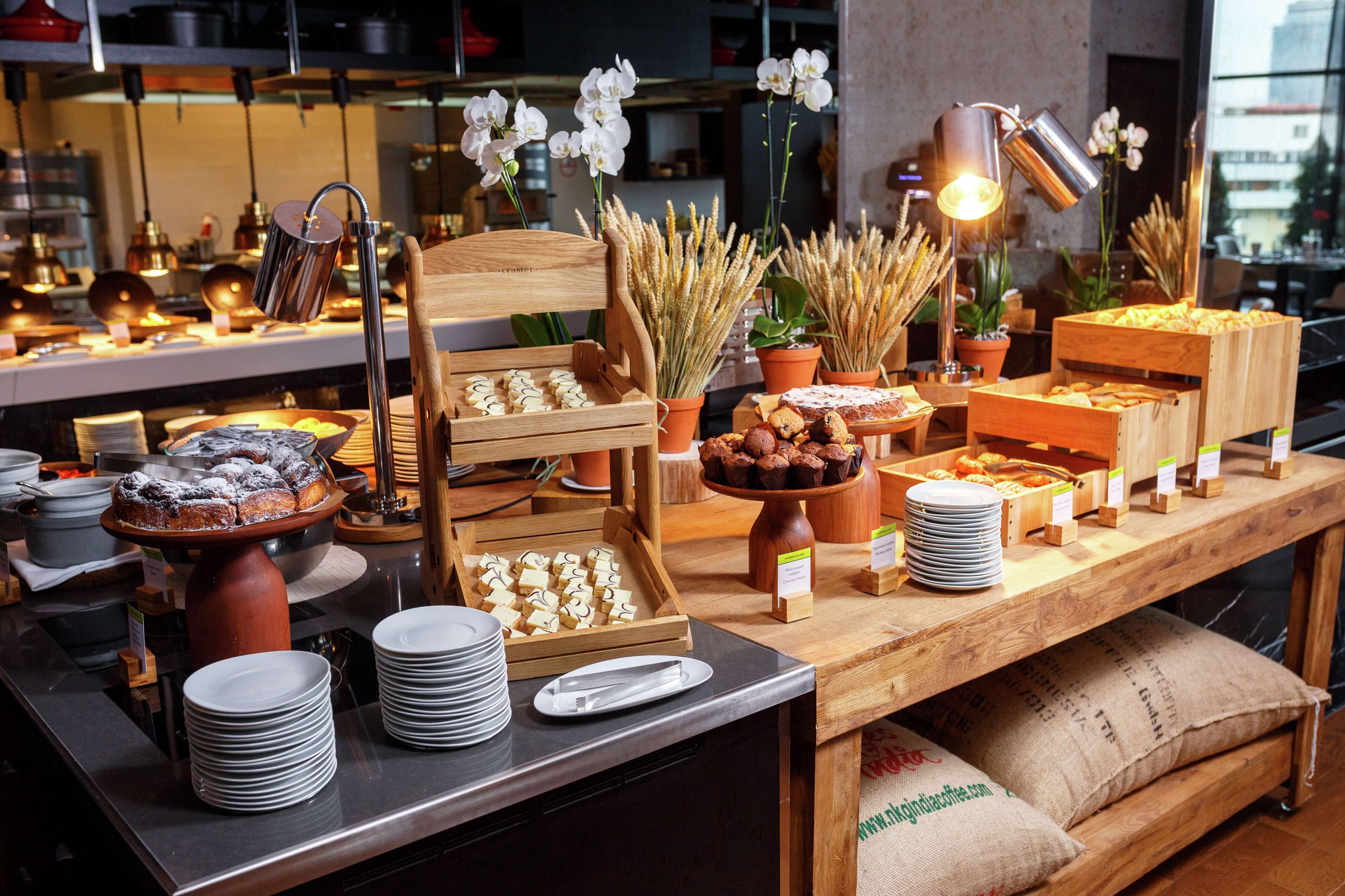 Un buffet proposant une variété de plats, d’assiettes et de plantes décoratives.