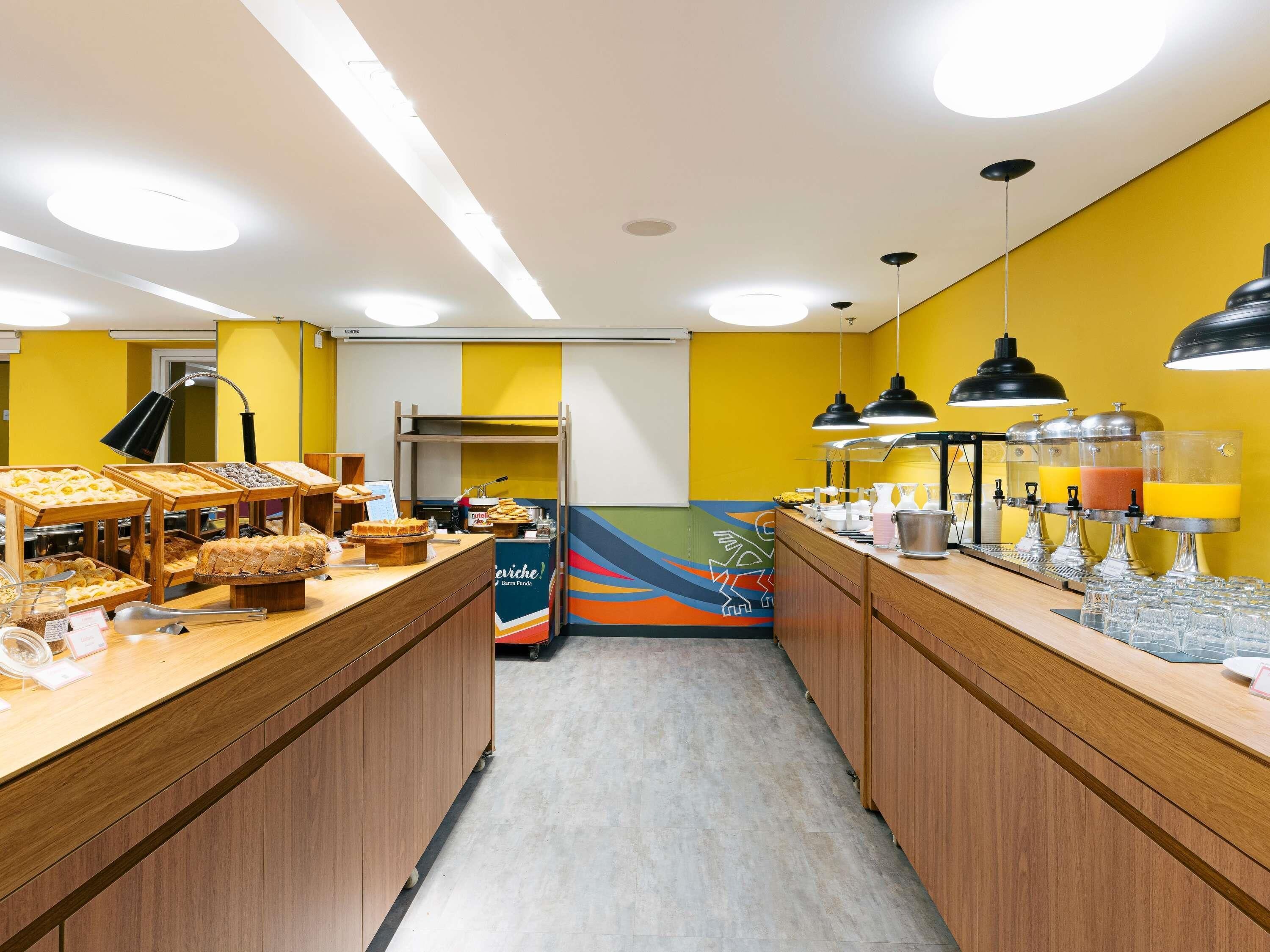 A breakfast bar with various food items and juice dispensers.