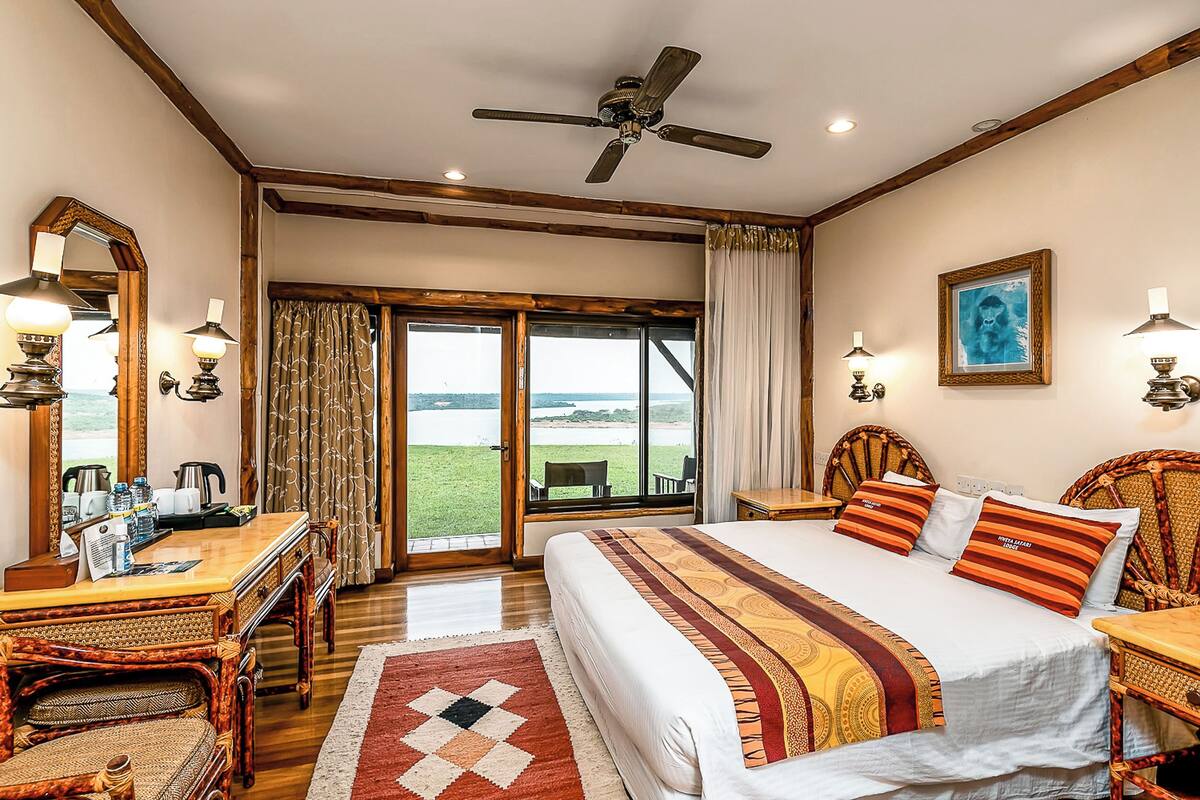 A spacious bedroom with a large bed, a desk, and a view of the outdoors.