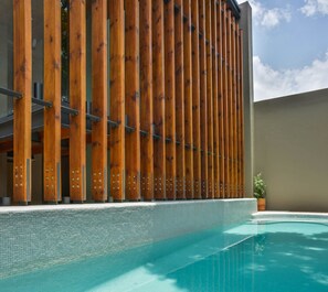 A pool area with a wooden fence and a tiled pool. - Hotel Criol (Querétaro)