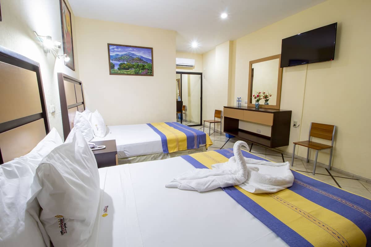 A hotel room with two beds, a desk, a chair, a TV, and a painting on the wall.