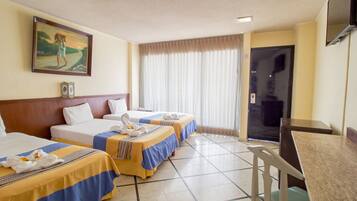 Una habitación de hotel con dos camas, una mesa de comedor, un televisor y un cuadro en la pared.