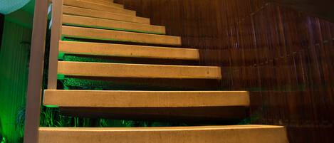 Una escalera de madera con barandilla que sube.