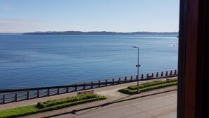 A coastal road with a guardrail, a lamp post, and a bench. - Hostal Vista al Mar (Ancud)