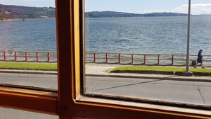 A view of a lake with a pedestrian path and a railing. - Hostal Vista al Mar (Ancud)