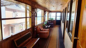 A wooden interior with a bench, two sofas, and a potted plant. - Hostal Vista al Mar (Ancud)