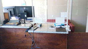 A reception desk with computers, a phone, and various office supplies. - Budget Lodge by OYO Portland West (Portland)