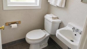 A bathroom with a toilet, sink, and window. - Budget Lodge by OYO Portland West (Portland)