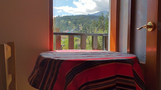 Habitación con vista a un paisaje montañoso a través de puertas de balcón.
