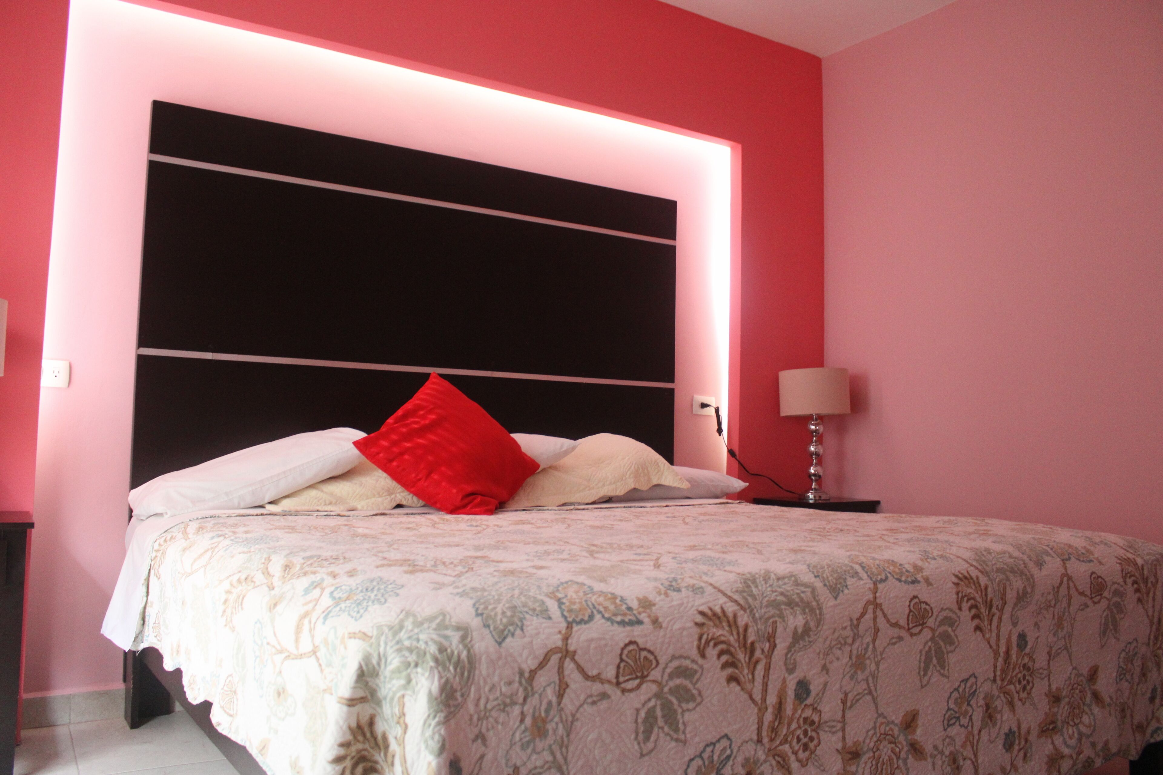 Une chambre à coucher avec un grand lit, une lampe de chevet et une table de chevet.