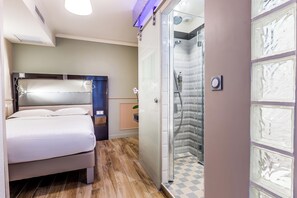 A hotel room with a bed, a shower, and a wall with decorative panels. - District Republique (Paris)