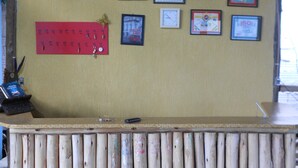 Un comptoir d’accueil avec un calendrier, des certificats encadrés et une horloge.