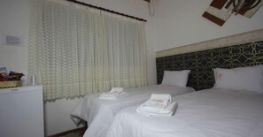 A hotel room with two beds, a refrigerator, and a window with curtains. - Pousada Rozam (Olímpia)