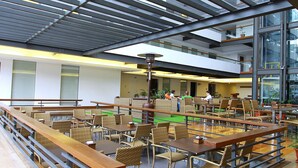 A spacious indoor dining area with high ceilings and large windows, featuring multiple dining tables and chairs. - Grand Sierra Pines Baguio (Baguio)