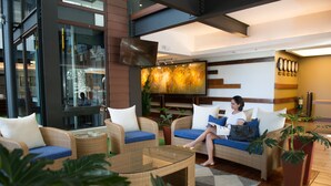 A modern lobby with wicker furniture, a glass coffee table, and a large painting on the wall. - Grand Sierra Pines Baguio (Baguio)