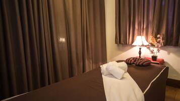 Relax in a spacious room with a large bed, bedside lamp, and a potted plant.