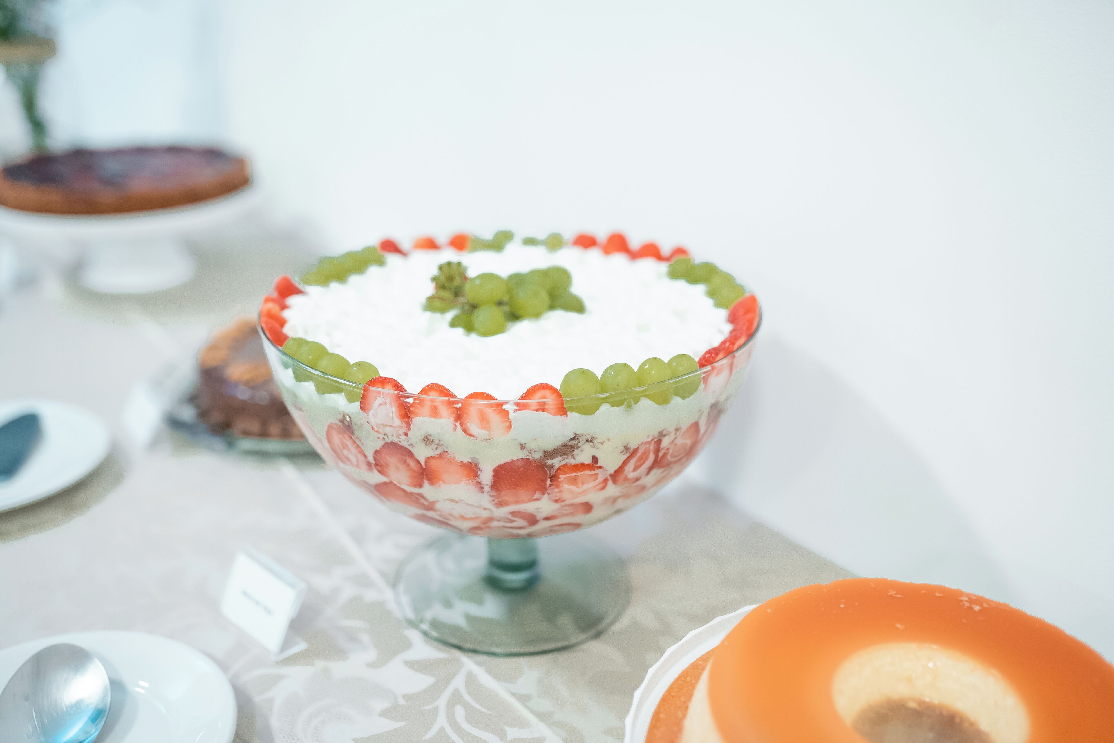 A dessert bowl with a decorative border and a central fruit arrangement.