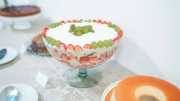 A dessert bowl with a decorative border and a central fruit arrangement.