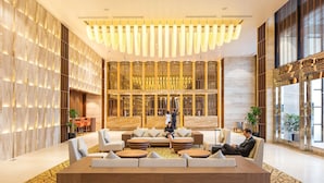 A spacious lobby with a large seating area, a high ceiling with modern lighting, and large windows providing natural light. - Wyndham Legend Halong Hotel (Bai Chay)