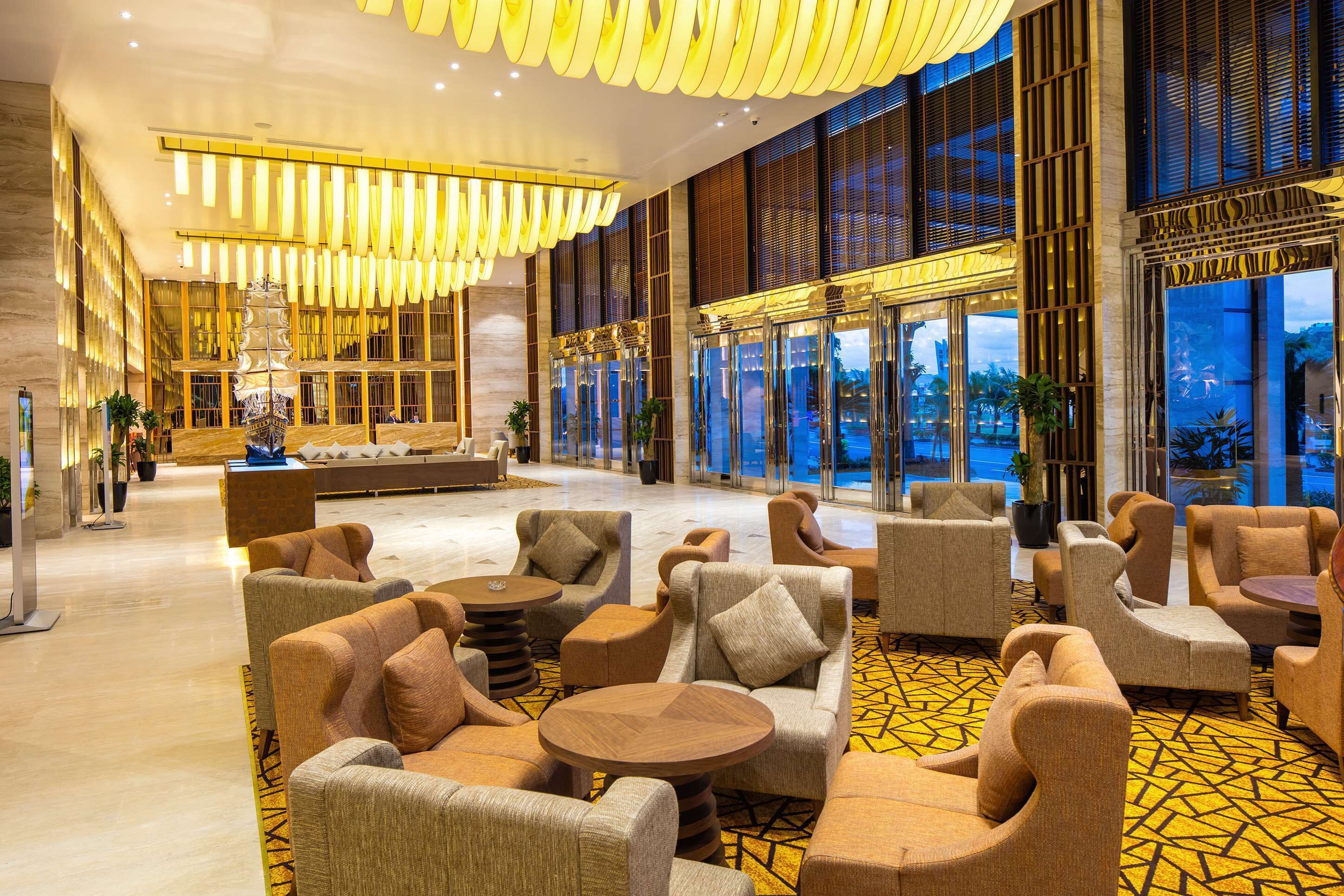 A spacious lobby with modern furniture, large windows, and a decorative fountain.
