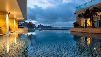 Una piscina al aire libre, sillones reclinables de piscina