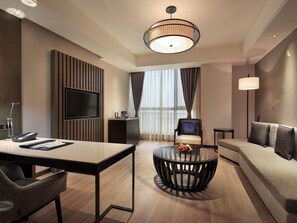 A modern hotel room with a TV, a round coffee table, a sofa, and a dining table. - Pullman Nanchang Sunac (Nanchang)