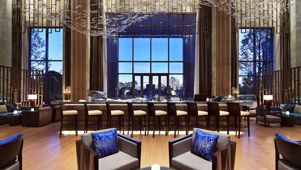 A spacious lobby with a bar area, seating arrangements, and large windows offering a city view. - Pullman Nanchang Sunac (Nanchang)