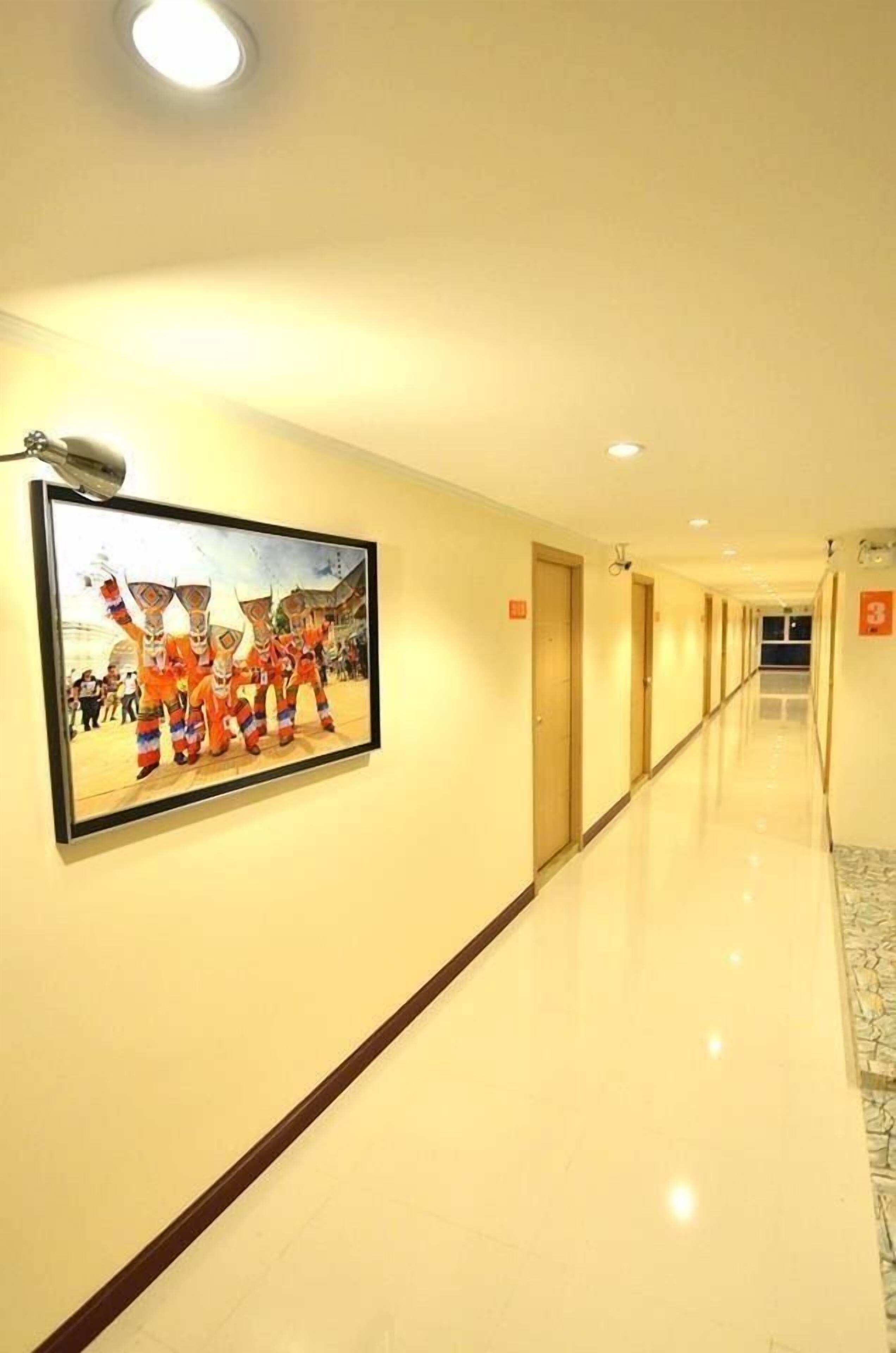 A hotel corridor with a framed picture on the wall, doors, and a sign indicating room number 3.
