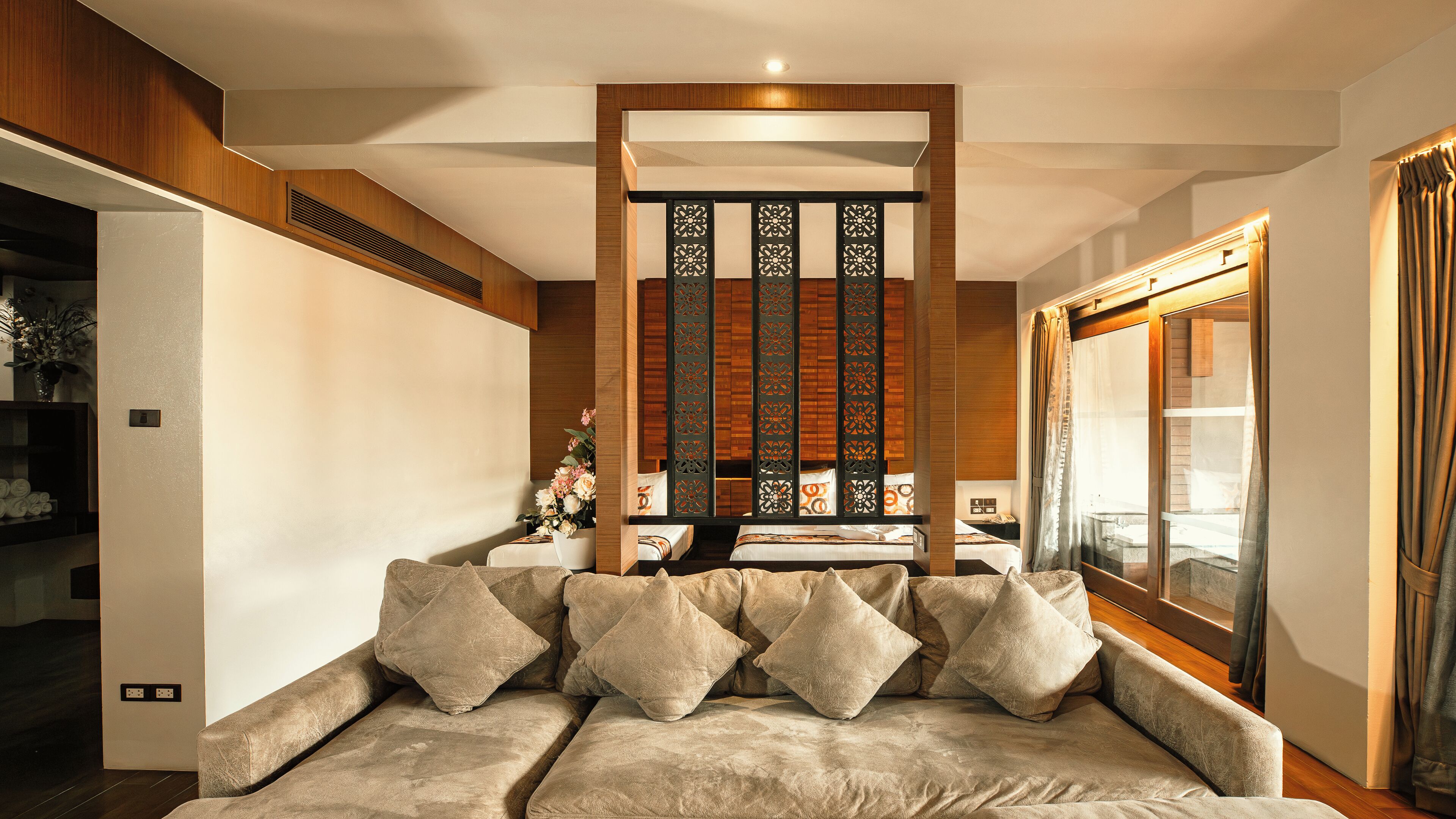 Una sala de estar moderna con un sofá, paneles decorativos y un ventanal grande.