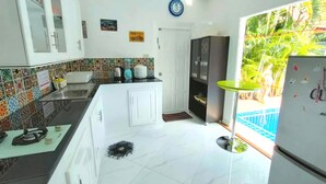 A modern kitchen with white cabinets, a tiled backsplash, and a countertop with a blender and toaster.