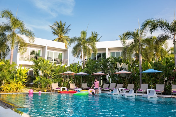 Alberca al aire libre, sombrillas en la alberca y camastros