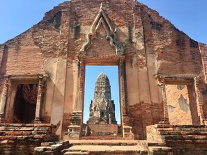 An ancient brick structure with a central doorway leading to a temple. - Pludhaya Resort & Spa (Ayutthaya)