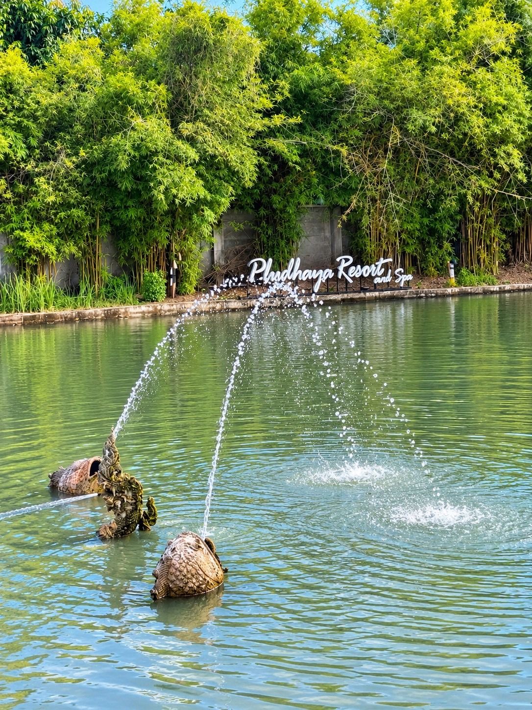 Una fuente de agua con un cartel que dice 'Phulhaya Resort and Spa' al fondo.