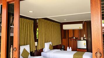 A hotel room with two beds, a wooden door frame, and a sign above the door.