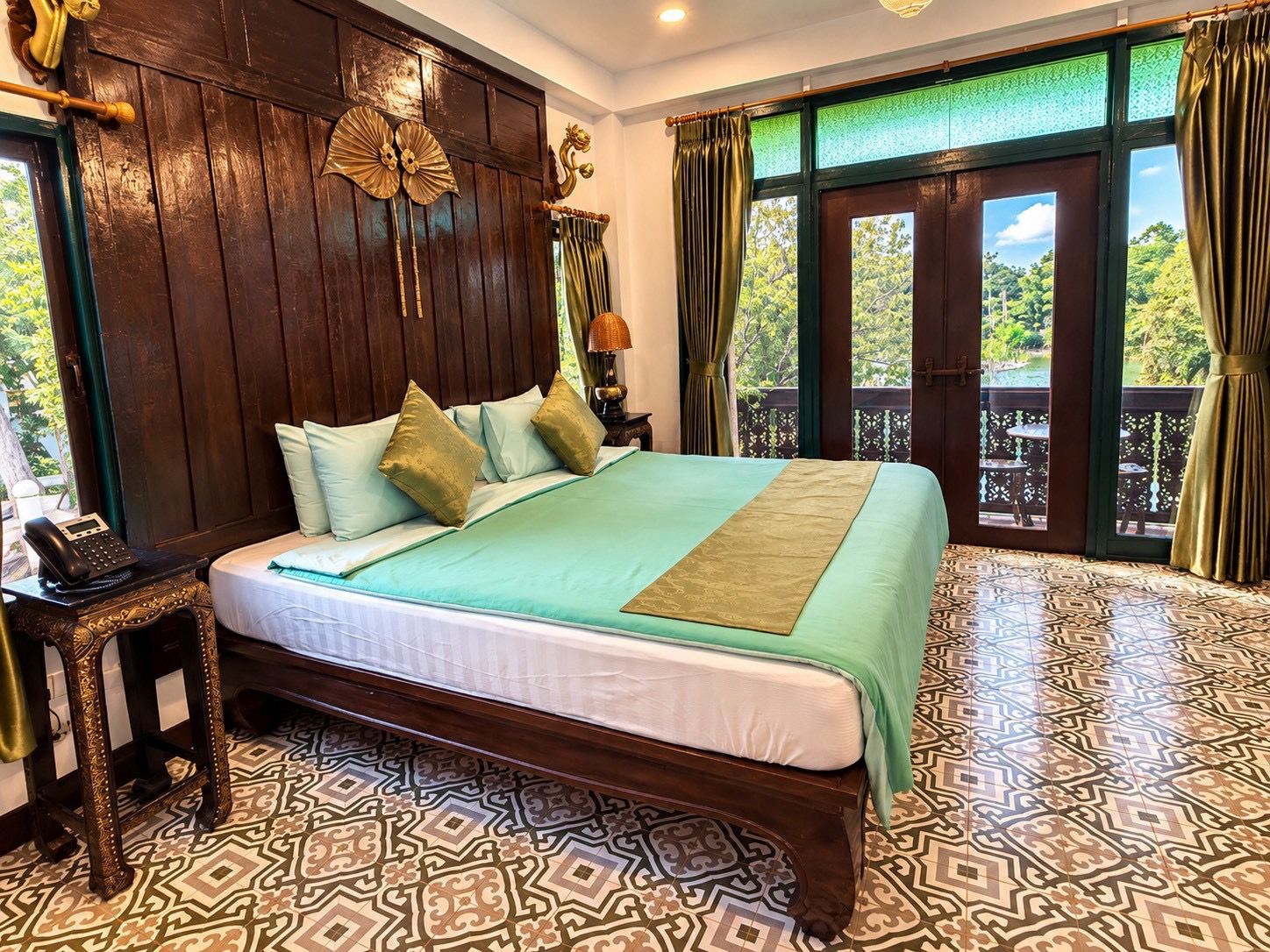 Una cama con piso estampado, cabecera de madera y vista a follaje exterior.