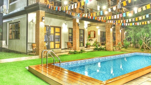 Ein modernes Gebäude mit Pool, Sitzgelegenheiten im Freien und farbenfroher Dekoration.