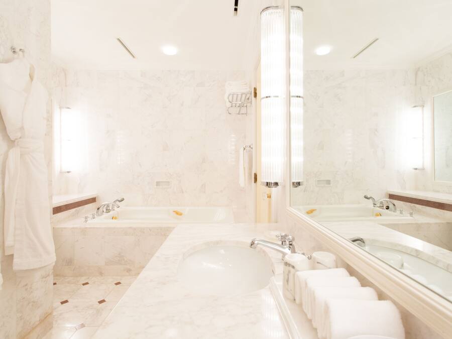 Une salle de bain luxueuse avec une grande baignoire, deux lavabos et un porte-peignoir.