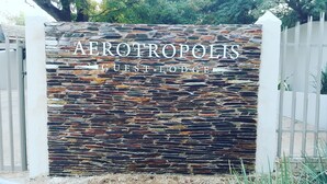 Un muro di pietra con la scritta "AEROTROPOLIS GUEST FORT" che indica un'area dedicata agli ospiti.