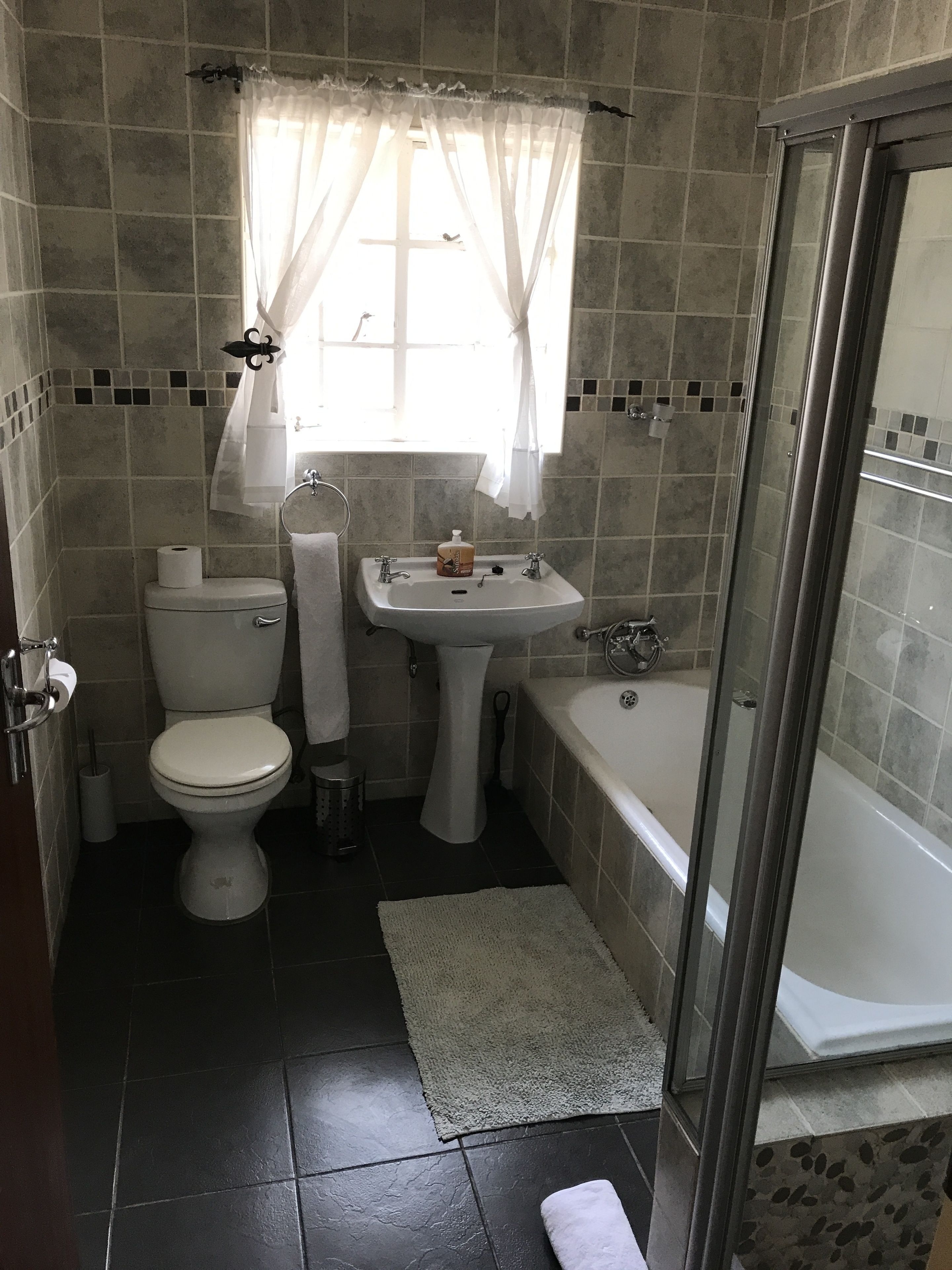 A bathroom with a toilet, sink, and bathtub.