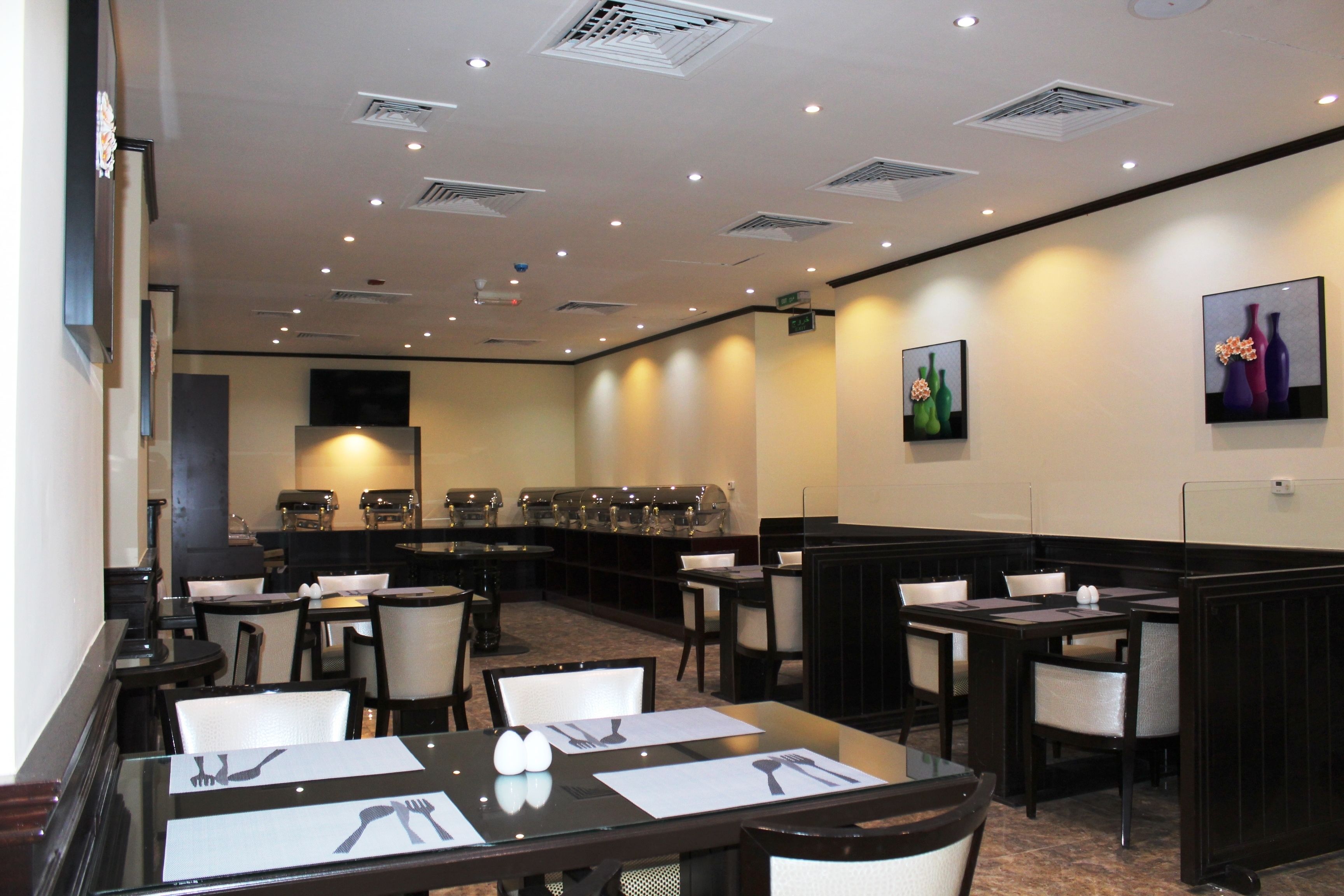 A restaurant with booths and tables, equipped with chairs, tables, and a buffet area in the background.