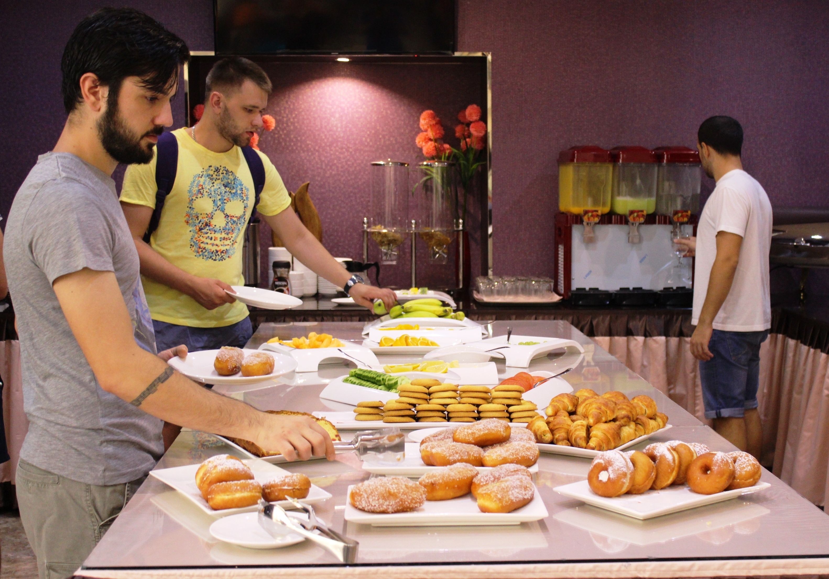 A buffet table with various food items including pastries and fruits.