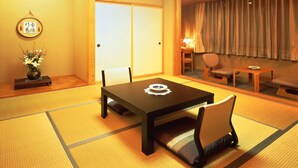 Une pièce de style japonais traditionnel, avec des tatamis, une table basse et des sièges.