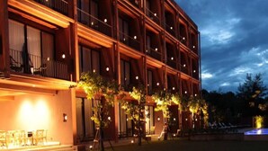 A multi-story hotel with a balcony on the second floor, outdoor seating area, and a pool. - The Glory River Kwai Hotel (Kanchanaburi)