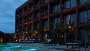 A hotel with a pool area, lounge chairs, and a building with multiple balconies. - The Glory River Kwai Hotel (Kanchanaburi)